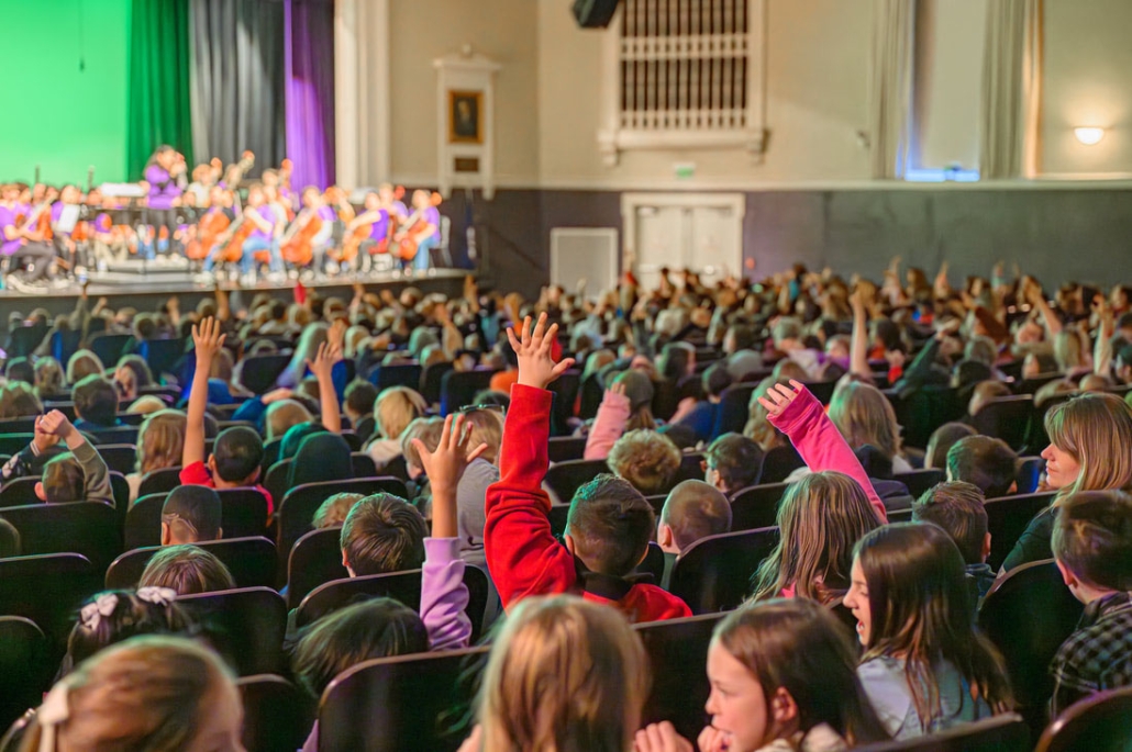 audience of children raising hands