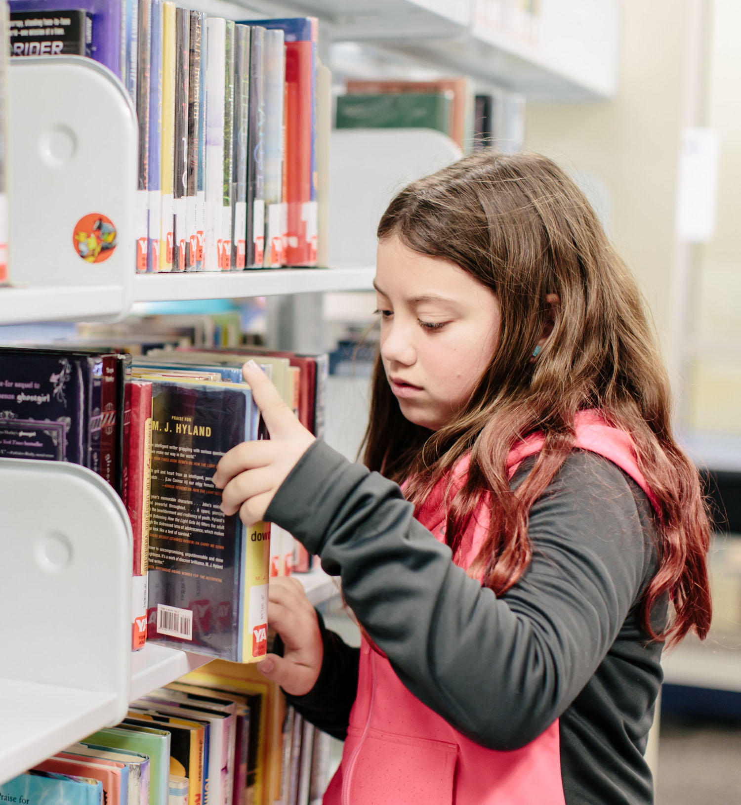 girl checking books in a library