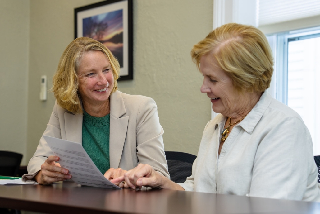 Two women review a report.