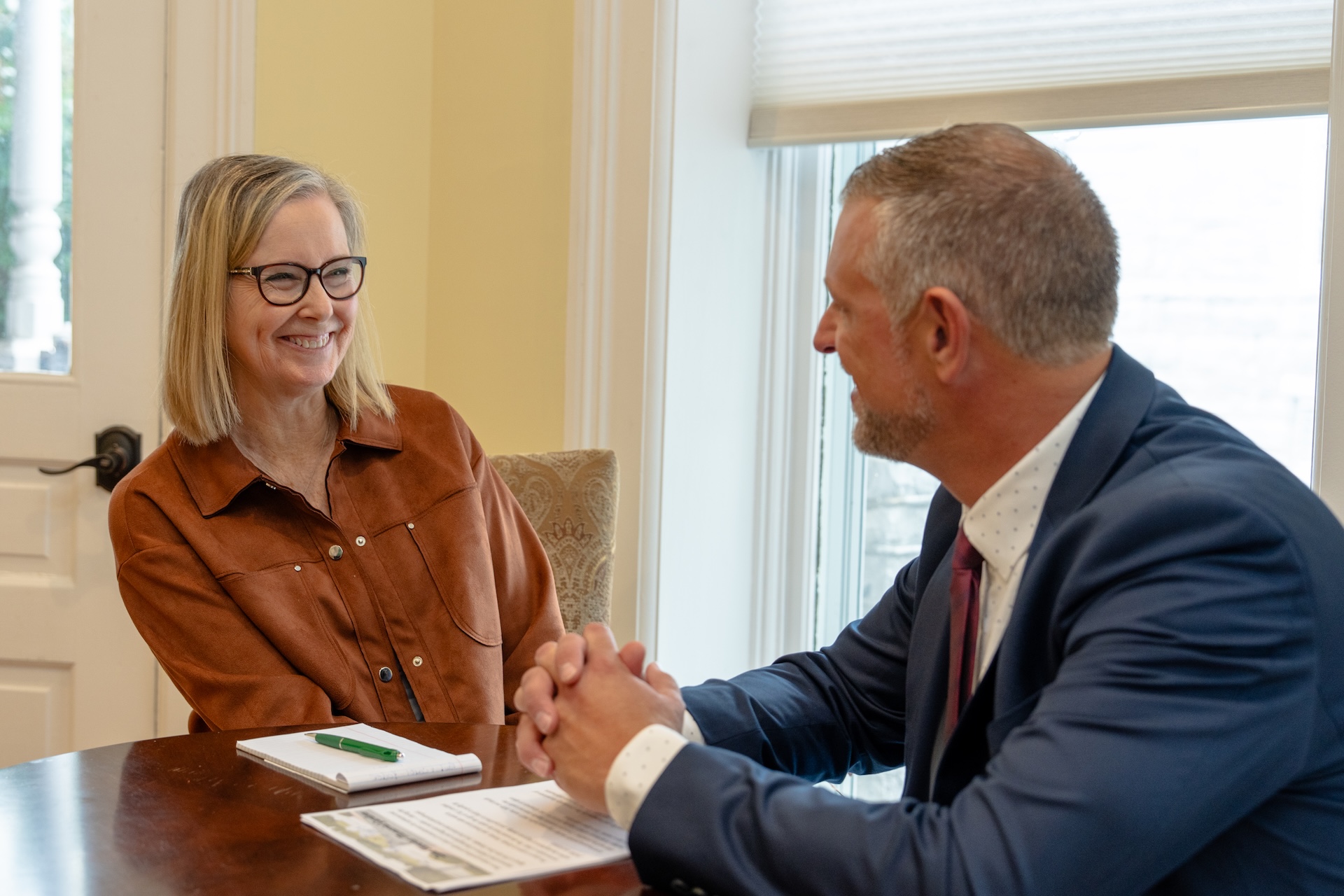 A woman and a man sit at a table to plan a gift.